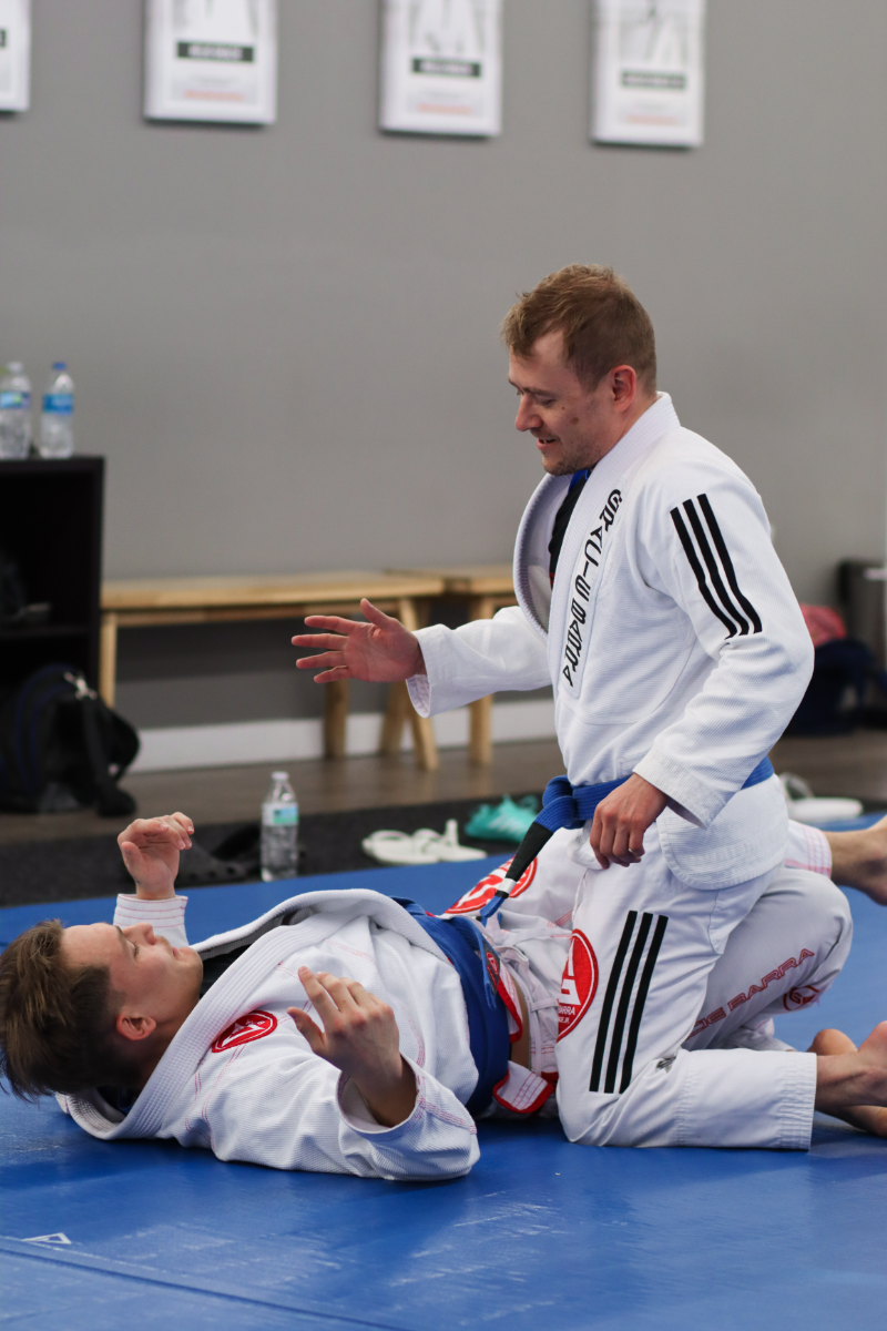 two men practicing Jiu Jitsu on the mats