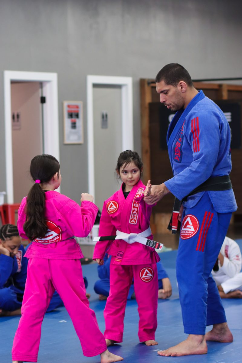 Prof. Seidler Rodrigo explaining Jiu0Jitsu to two little girls 