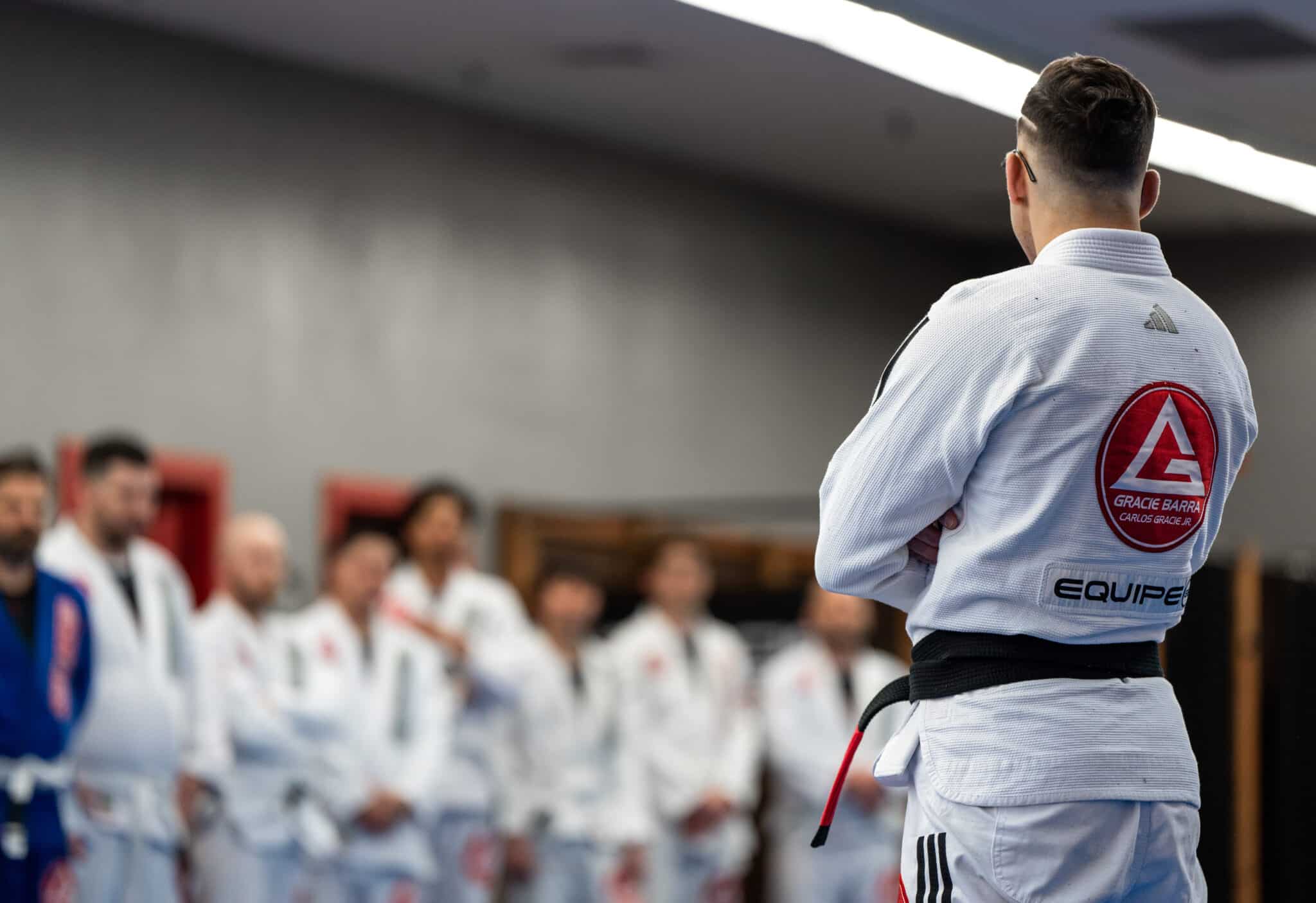 Coach Carlos was standing showing Gracie Barra logo on his back looking at the lined up students at Gracie Barra Salt Lake City