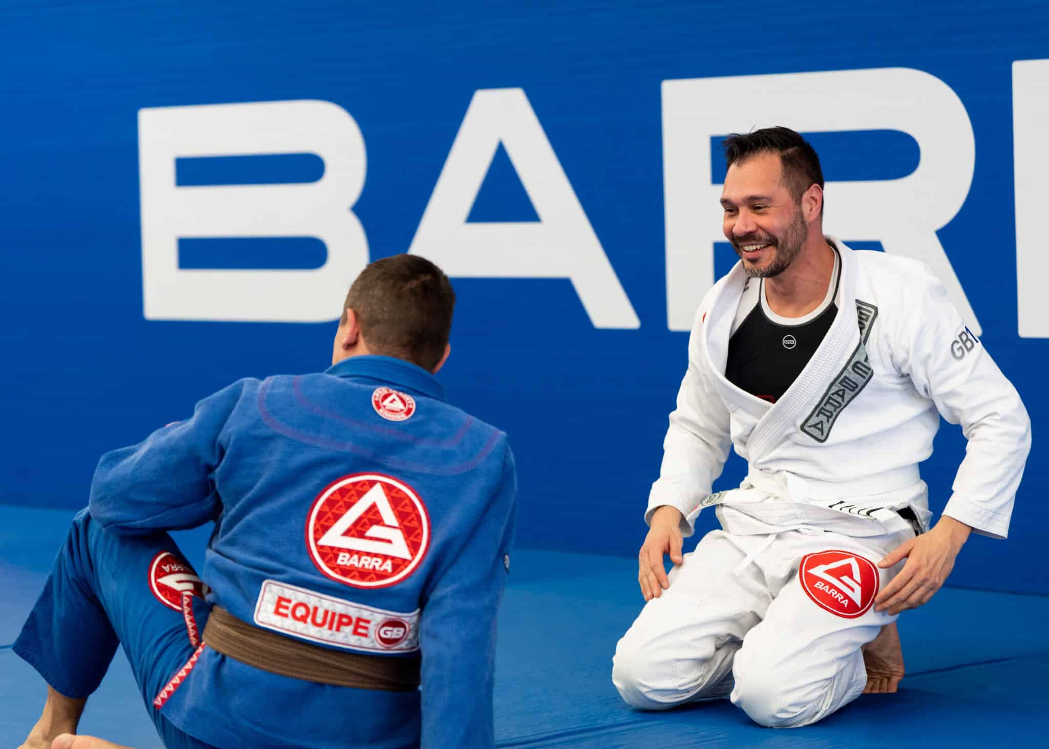 two adults students talking on the mat at gracie barra salt lake city